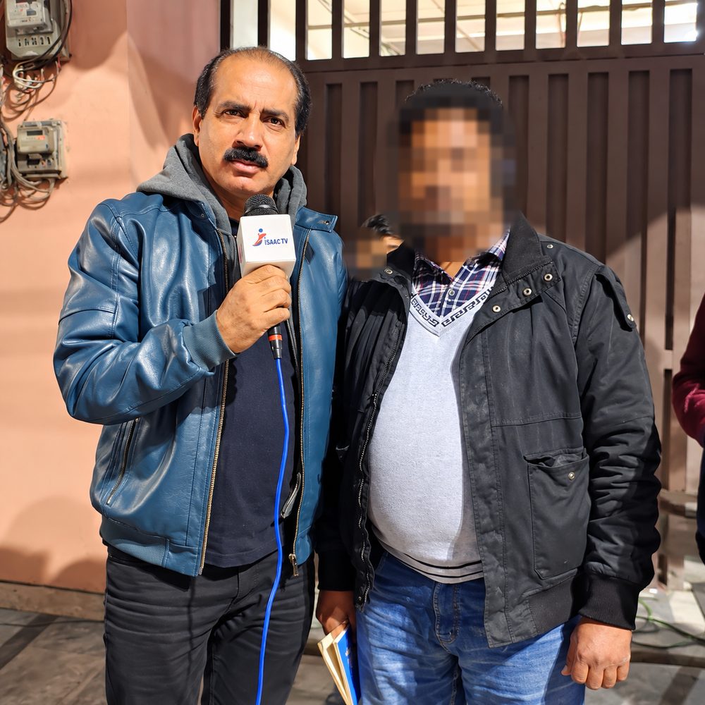 Saleem Iqbal interviewing a community member at night